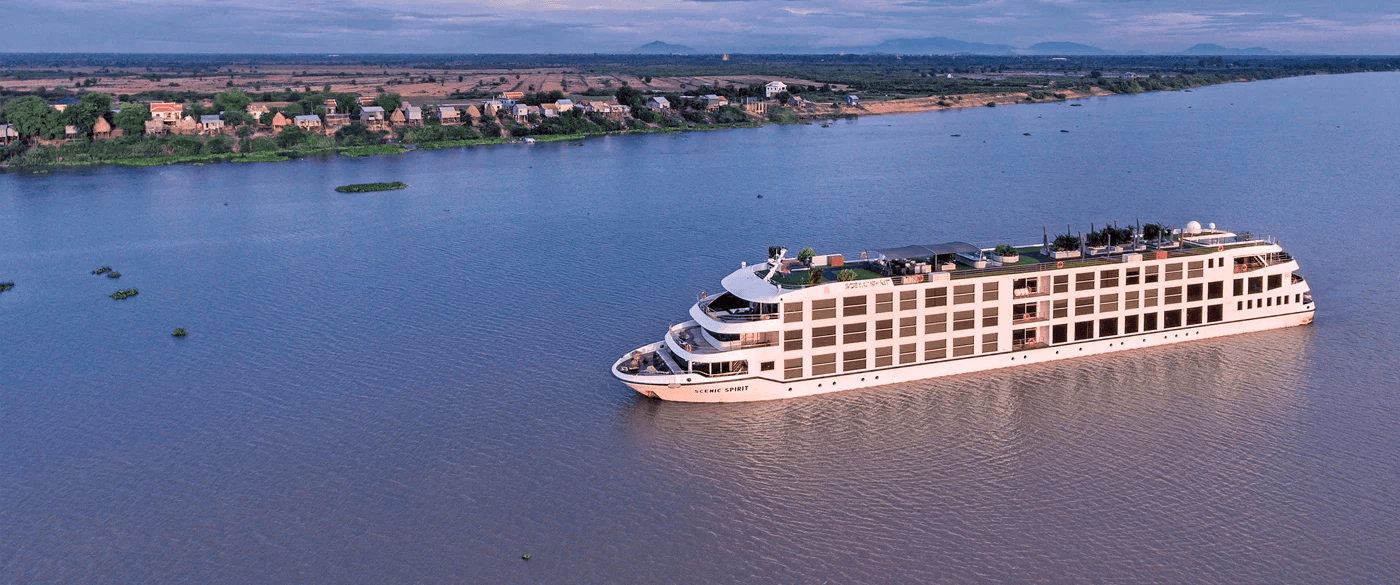 The Scenic Spirit ship cruising on the Mekong River at sunset.