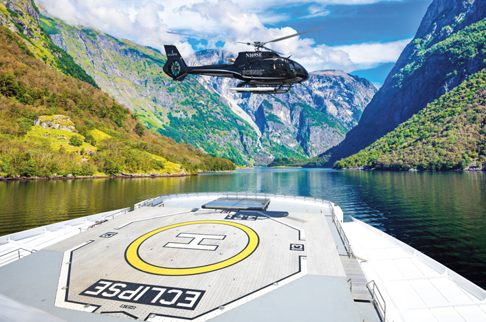 Helicopter coming in for landing on ship helipad in Fjords
