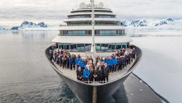 The crew of Scenic Eclipse standing together on the dec, enjoying the view and the fresh air of the Arctic.