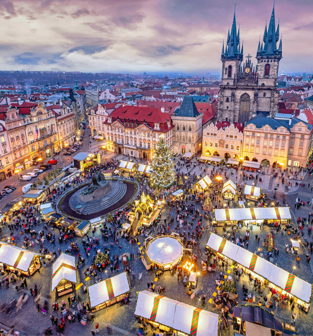 Birdseye view of town square transformed into Christmas market with stalls and lights