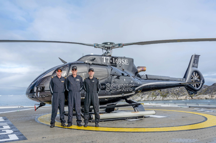 Helicopter pilots stood in front of the helicopter