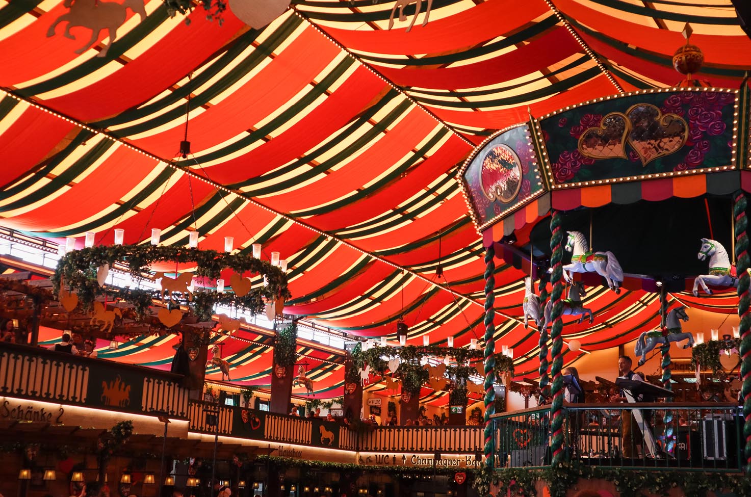 Bavarian beer hall in Munich under red sail roofs.